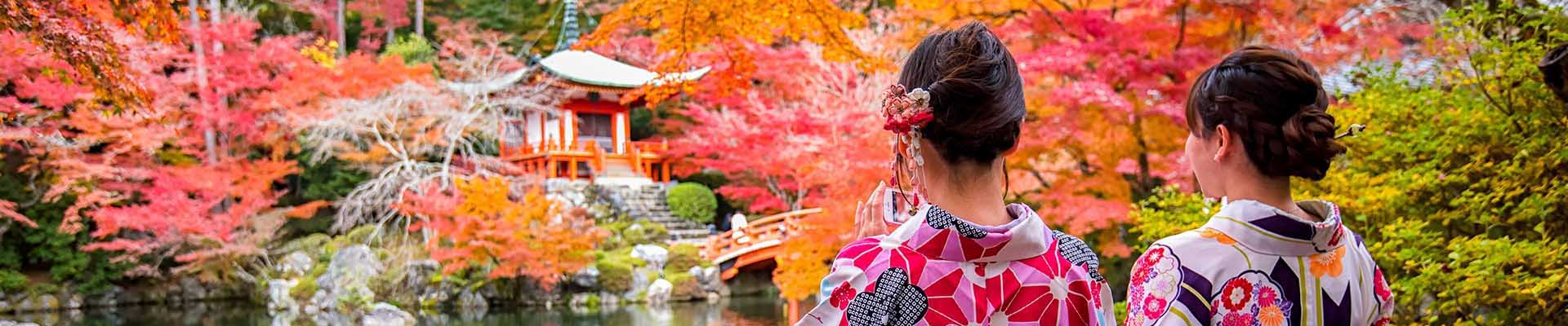 Due donne giapponesi in kimono contemplano i momiji a Kyoto