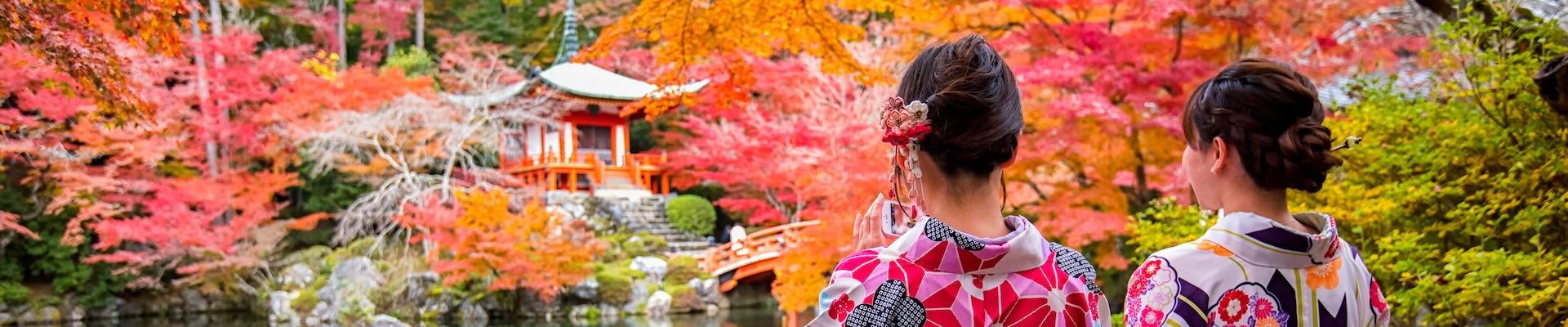 Due donne giapponesi in kimono contemplano i momiji a Kyoto